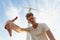 A sassy teenager on a blue sky background. Close-up of stylish hipster guy next to a windmill. Teenage years concept.