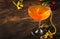 Satans whiskers, halloween cocktail with gin, vermouth, orange juice and liquor, vintage dark wooden background with festive decor