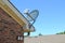 Satellite Company Satellite Dish Mounted to the Roof of an Apartment Building.