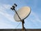 Satellite dish antenna over blue sky background