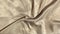 Satin beige fabric background. Wavy silk fabric. Slow motion of fabric