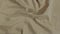Satin beige fabric background. Wavy silk fabric. Slow motion of fabric