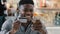 Satisfied african american man makes purchase in online store pays for goods with credit card on mobile phone uses e