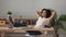 Satisfied African American woman relaxing with legs on table