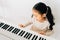 Satisfied Asian kid playing piano at home