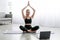 Satisfied caucasian beautiful young blonde woman practicing yoga in lotus position, exercising at home