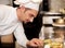 Satisfied chef analyzing dish before serving