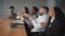 Satisfied diverse employees sitting in conference room listen colleague presentation clap hands in meeting happy