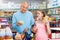 Satisfied father doing shopping with preteen girl in supermarket