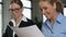 Satisfied female boss looking through work documents, prepared by colleague