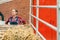 Satisfied female farmer with hay wagon