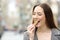 Satisfied girl eating a cereal snack bar on a city street