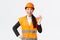 Satisfied happy asian female engineer, construction manager in safety helmet and reflective jacket showing okay gesture