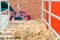 Satisfied happy female farmer with hay wagon