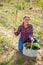 Satisfied Hispanic woman showing harvest of vegetables in garden