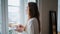 Satisfied lady enjoying cup of coffee at home closeup. Woman watching window