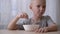 Satisfied little boy eating cereal with milk for breakfast.