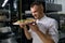 Satisfied male chef enjoying smell of just baked pizza