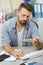 Satisfied man standing checking brush in computer