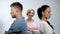 Satisfied mother looking at couple in quarrel standing back to each other