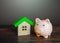 Satisfied piggy bank near the house. Low cost utilities and high energy efficiency. Housing green technologies. Autonomy and self-