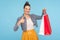 Satisfied shopaholic. Portrait of pleased happy woman with hair bun in fashionable clothes showing thumbs up like gesture