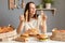 Satisfied smiling woman wearing white t- shirt siting at table with junk food in kitchen eating pasta breaking diet enjoying