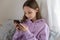 Satisfied teen girl looking at smartphone screen, chatting online
