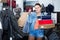 satisfied teenager girl holding boxes in shoes boutique