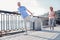 Satisfied unshaken man holding by the railing doing stretching exercises.