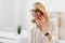 Satisfied woman using smartphone in the office