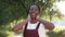 Satisfied young African American slim woman dancing in slow motion in sunrays outdoors. Portrait of excited cheerful