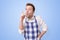 Satisfied young man in apron showing index fingers up, giving advice how to cook.