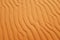 Saturated orange color desert sand wave patterns for a warm summer background.