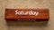 Saturday and Sunday text on wooden block against handmade bark paper, calendar concept