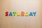 Saturday word written with colorful letters on wooden table background