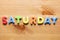 Saturday word written with colorful letters on wooden table background