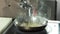 Sauce boat pouring onto hot pan, slow-mo.