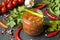 Sauce ketchup, Lecho in glass jar. Chili tomato cherry garlic and other spices on black background