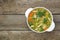 Saucepan of delicious vegetable soup with chicken on wooden table, top view. Space for text