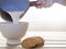 Saucepan pouring milk in bowl to breakfast