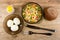 Saucer with boiled eggs, salt, knife, fork, bowl with vegetable mix, bread on wooden table. Top view