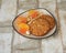 Saucer with oatmeal cookies, marmalade and cashew nuts on wooden background