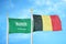 Saudi Arabia and Belgium  two flags on flagpoles and blue cloudy sky