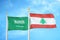 Saudi Arabia and Lebanon two flags on flagpoles and blue cloudy sky