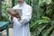 Saudi business asian man using tablet,standing in green cafe wear muslim dress ,freelance business concept