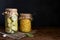 Sauerkraut and pickled squash in jars on a dark background