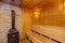 The sauna is lined with wood. Sweating room. Stove. Heater with stones for steam. Shelves for sitting and steaming.