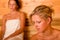 Sauna two women relaxing sweating covered towel