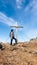 Sauofen - A woman with hiking backpack standing under a wooden cross on top of Sauofen in Austrian Alps. A vast, golden pasture